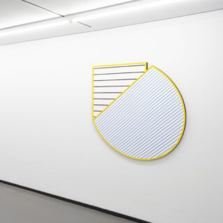 Abstract wall object with a yellow outline and fine black and blue lines on a white background.