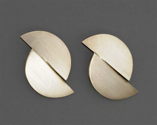 Zwei geometrische Ohrclips in Form zweier Halbkreise.
