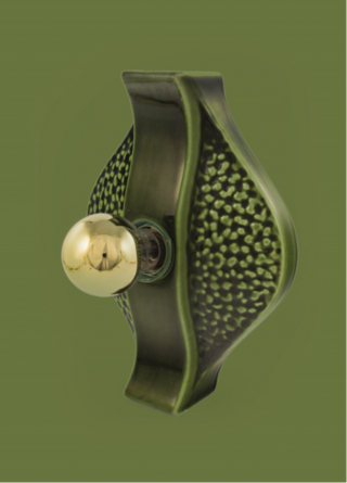 Green, organically shaped wall sconce made of green ceramic, against green background.