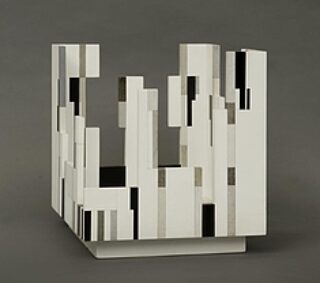 Cubical sculpture with vertical and horizontal rectangular cutouts on a square base.