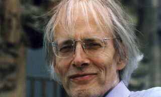 Older man with gray hair and glasses.